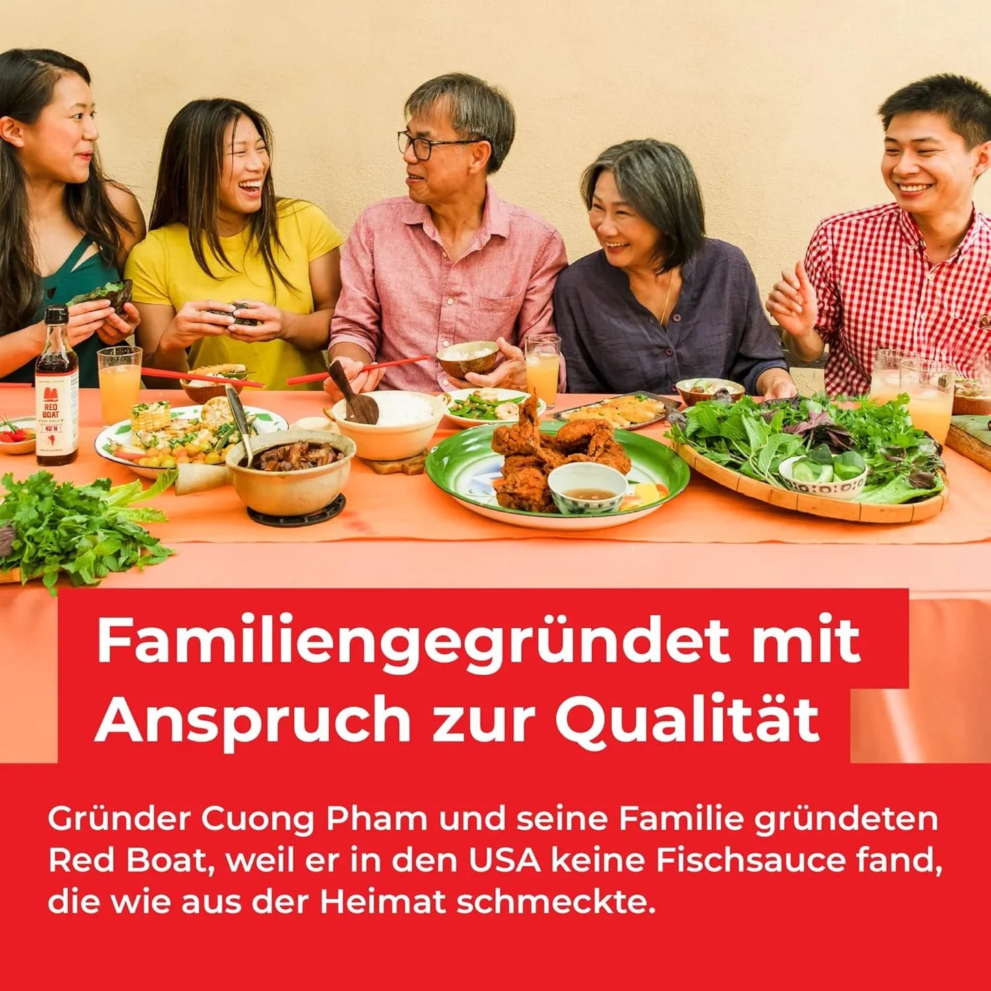 Familie genießt asiatisches Essen am Tisch mit Red Boat Fischsauce Flasche im Vordergrund