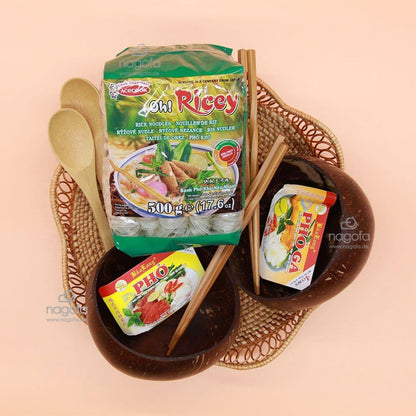 Asiatische Pho Reisnudeln, Gewürzmischungen, Kokosnussschalen und Essstäbchen auf Tablett