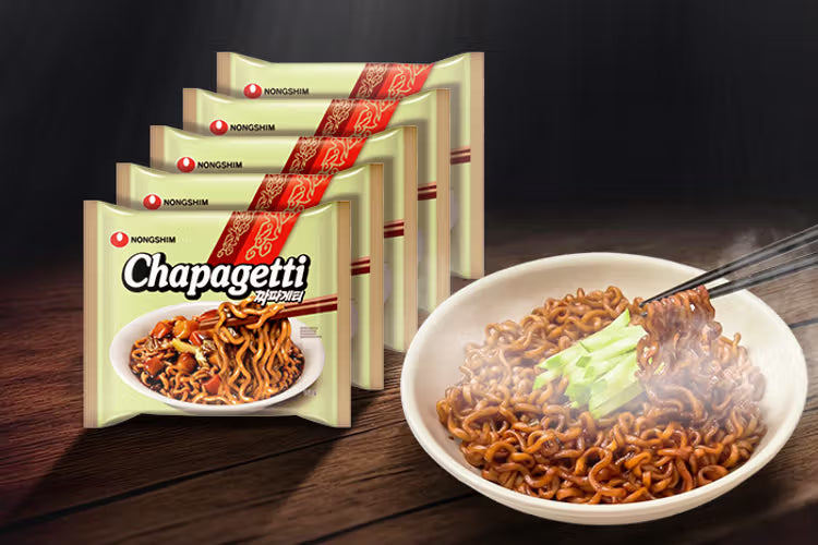 Chapagetti Instant-Nudeln in Verpackung und dampfende Schüssel mit schwarzen Bohnen-Nudeln